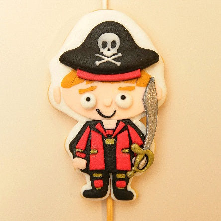 A cookie candle of a pirate boy holding a sword 