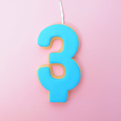 Blue number 3 cookie on a pink background