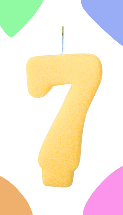 Yellow number 7 cake topper on a colorful background