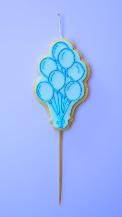 Blue Balloon-themed candle on a stick against a purple background