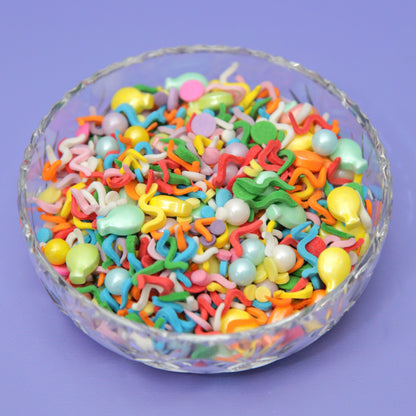 A brightly coloured bowl of wiggly rainbow confetti sprinkles with sugar balloons