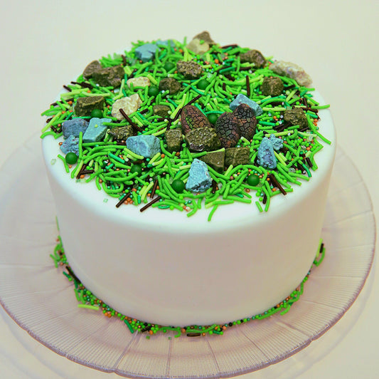 White cake with green sprinkles on a white cake 