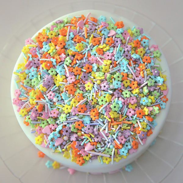 Colorful flower-shaped sprinkles on a white cake 