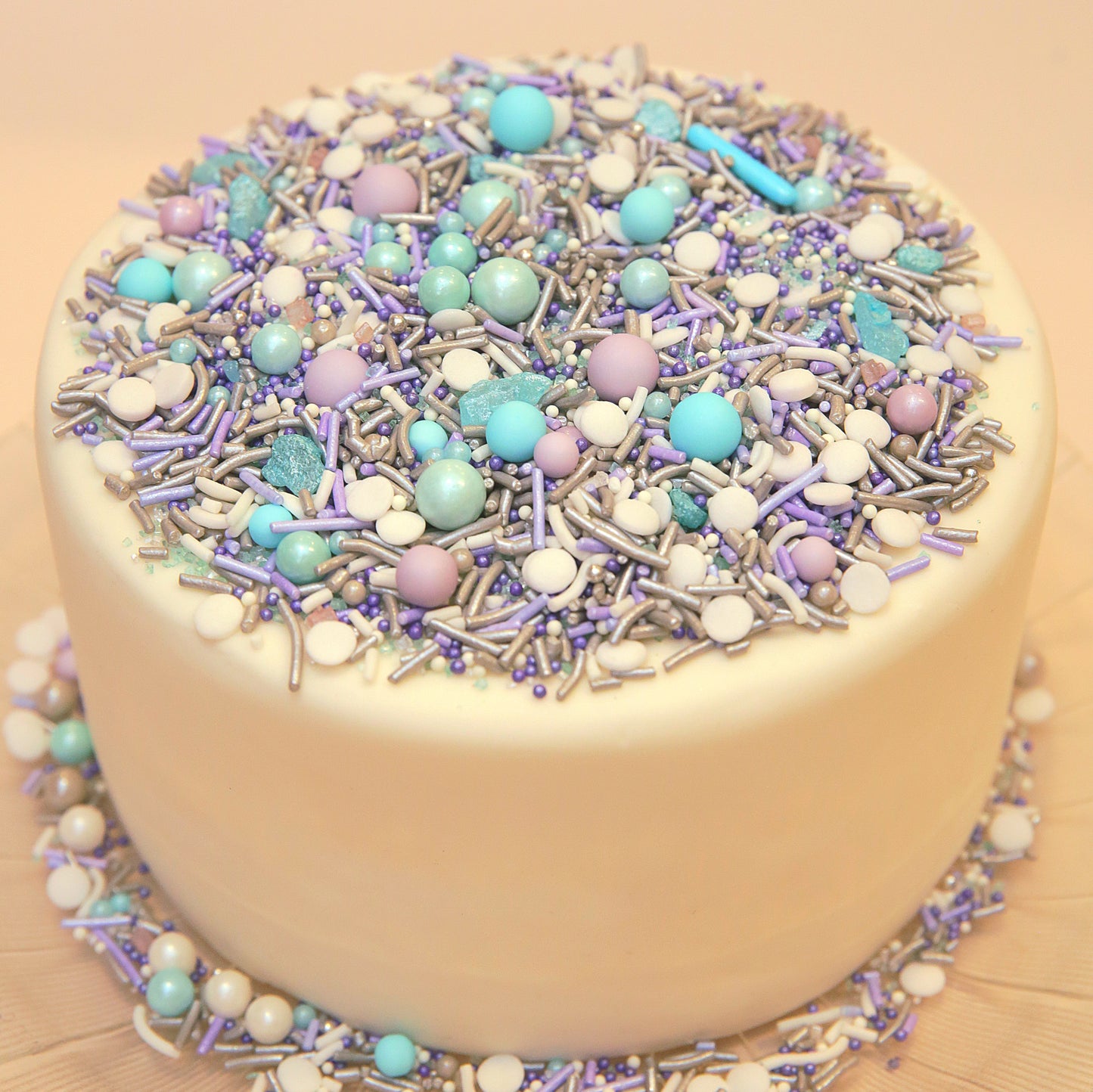 Purple and blue decorative white cake with colourful sprinkles