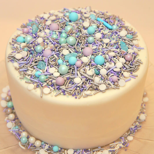 Purple and blue decorative white cake with colourful sprinkles