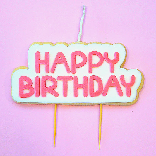 Cookie Candle with pink 'Happy Birthday' text on a pink background