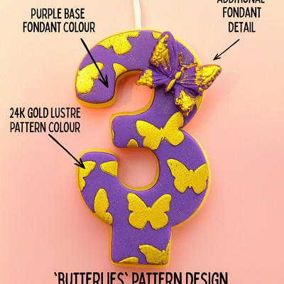 Decorative number '3' edible birthday candle with purple base, gold lustre, and butterfly pattern on a pink background.