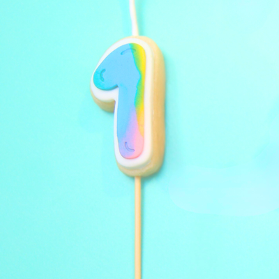 Colorful number '1' birthday candle on a blue background