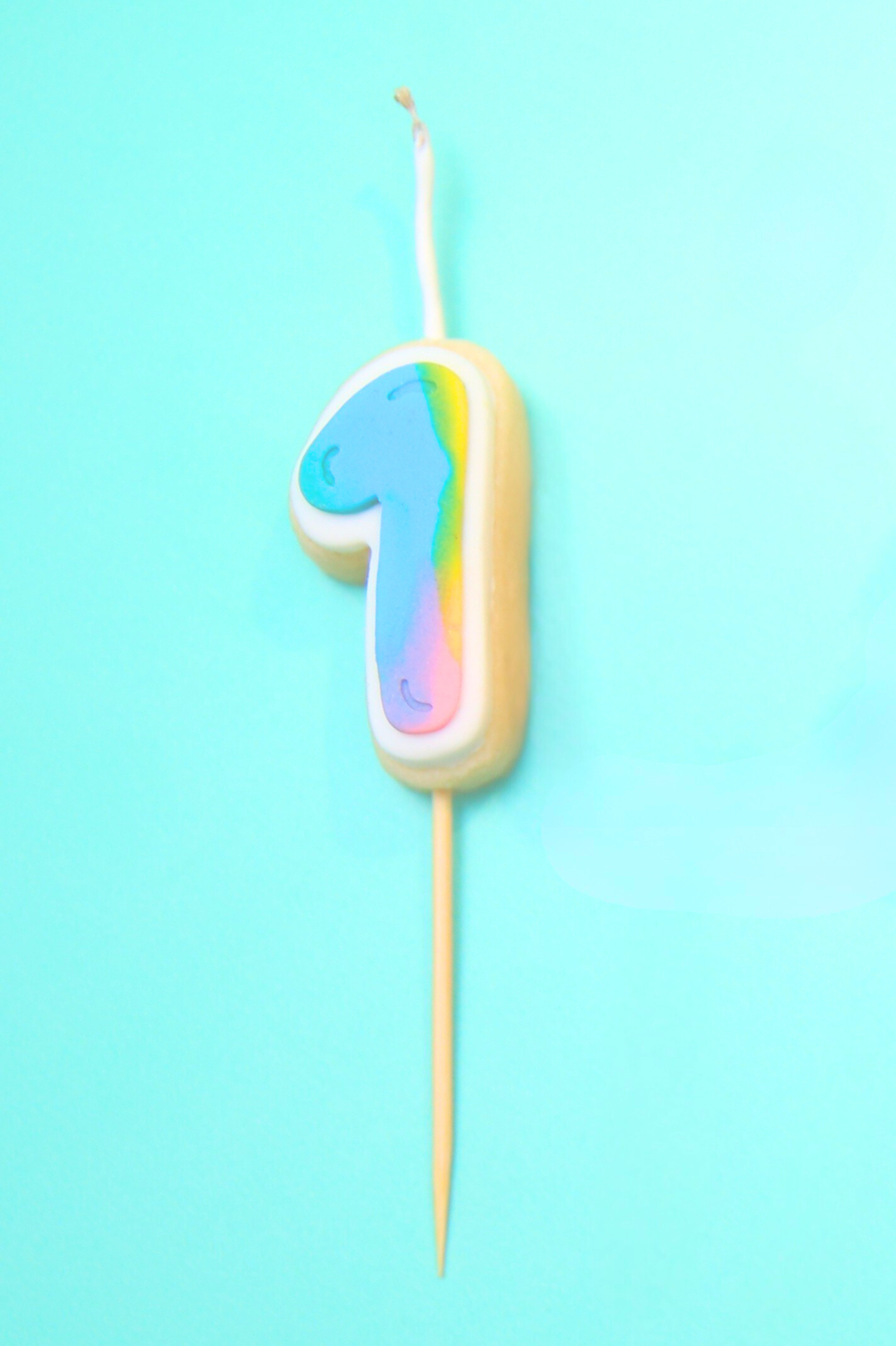 Colorful number '1' birthday candle on a blue background