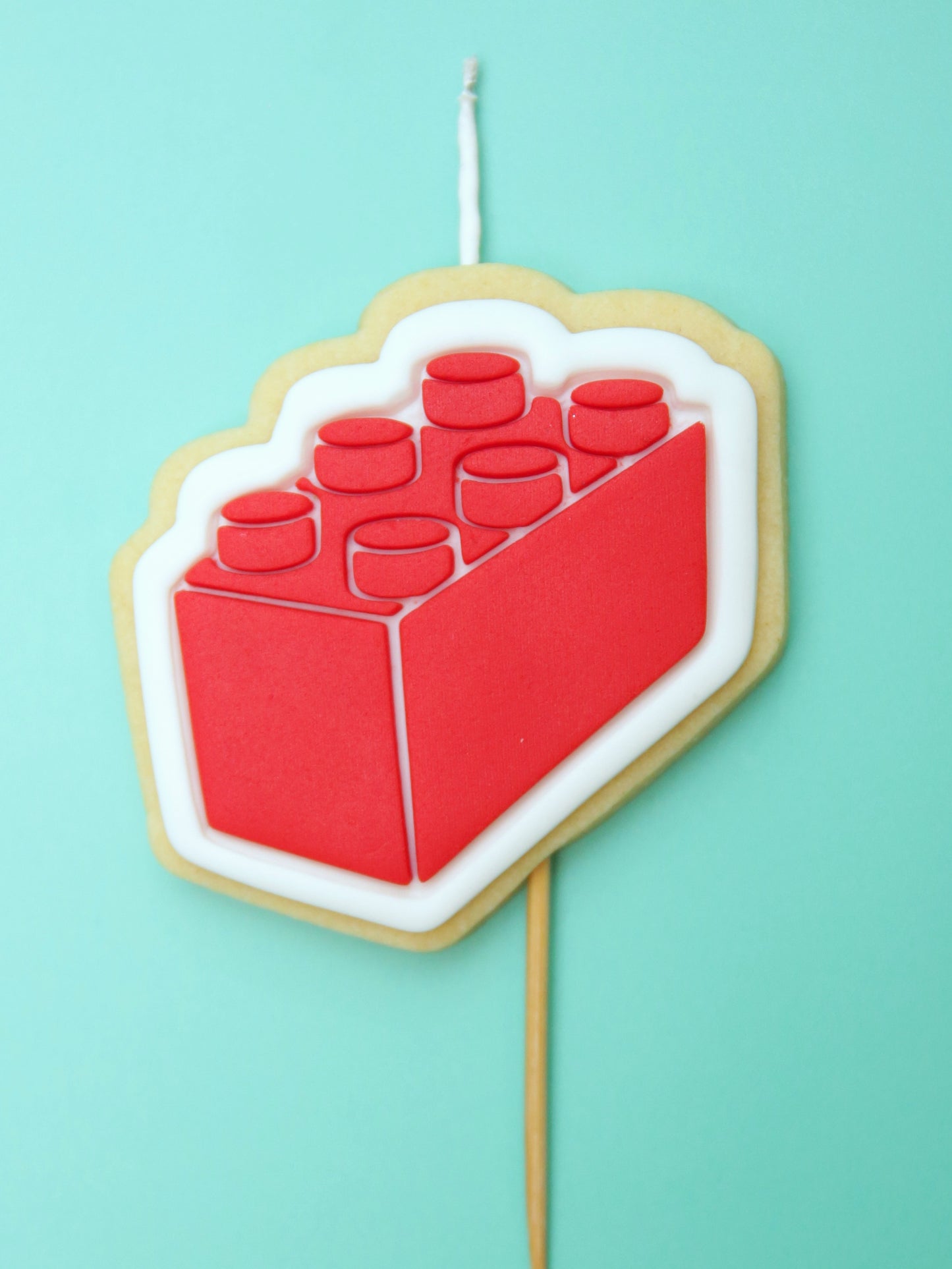 Red and white cookie with a block design on a light blue background