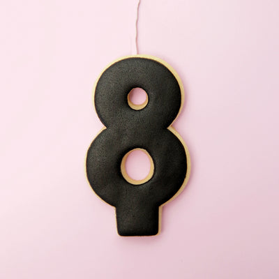 Black number 8 cookie on a pink background