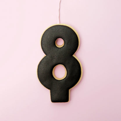 Black number 8 cookie on a pink background