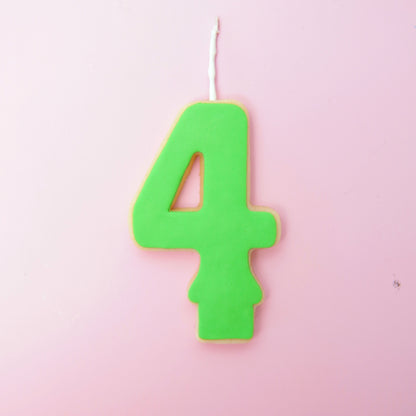 Green number 4 candle on a pink background