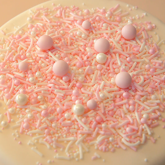 Close-up of a cake covered in pink and white sprinkles on a beige background