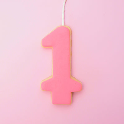 Pink number '1' cookie on a pink background