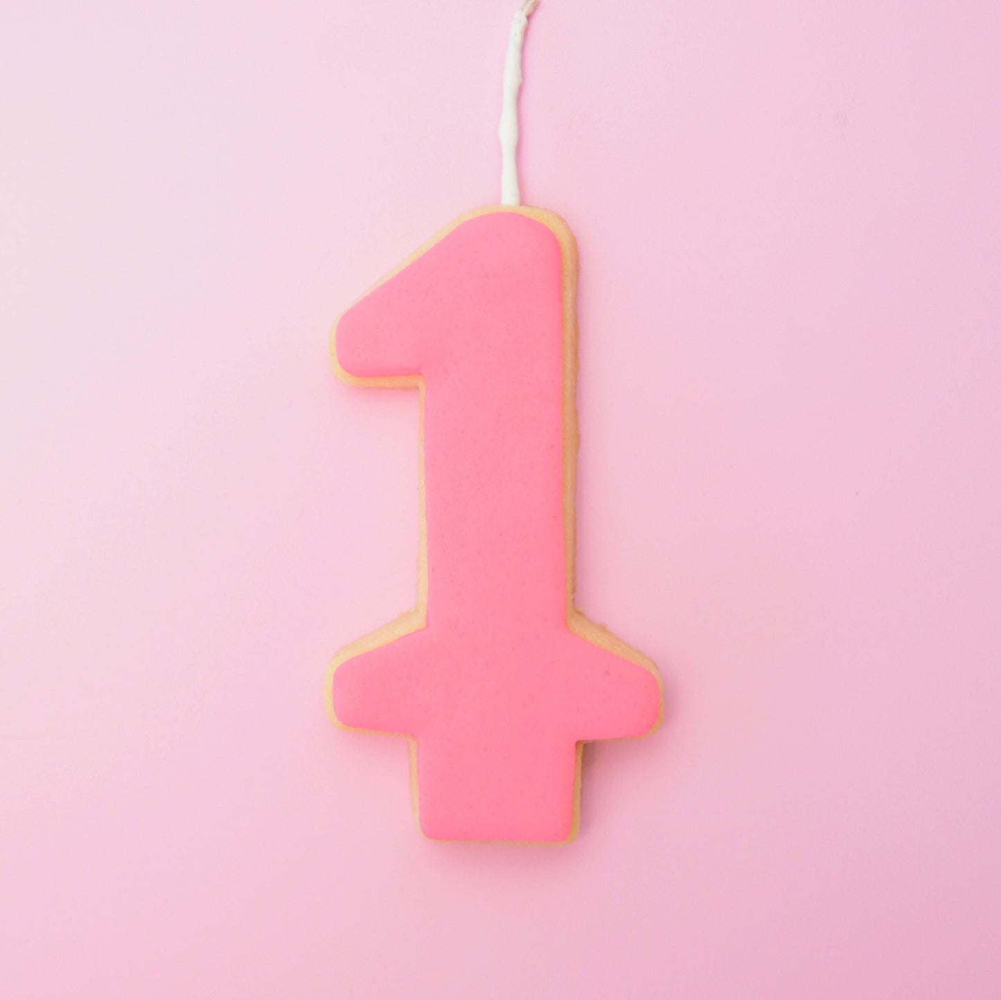 Pink number '1' cookie on a pink background