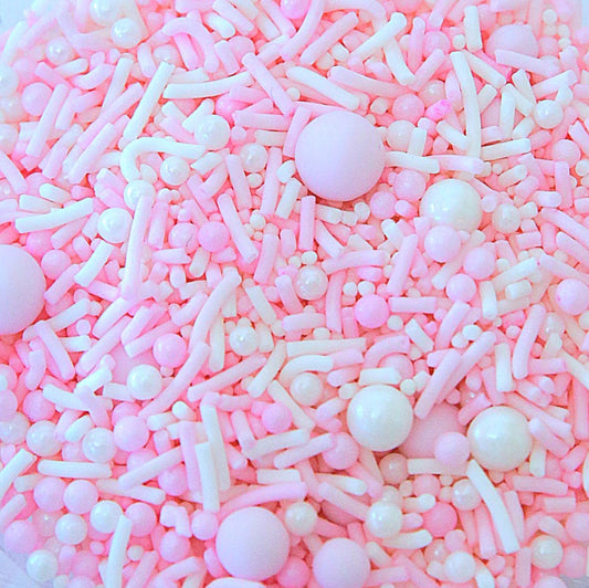 Pink and white sprinkles in a clear bowl