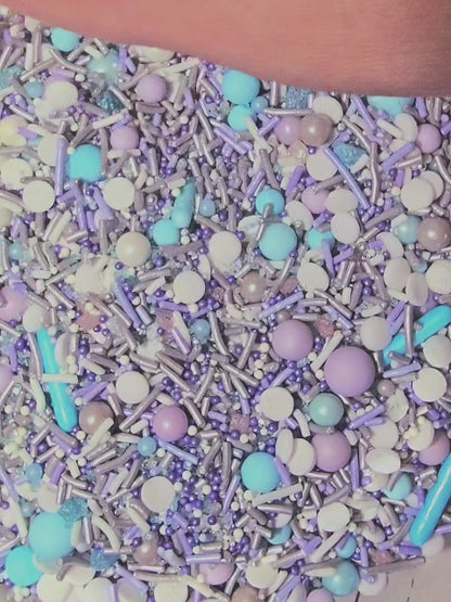 blue, purple and silver mix of sprinkles being scooped up