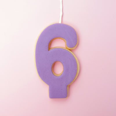 Purple number 6 cookie on a pink background