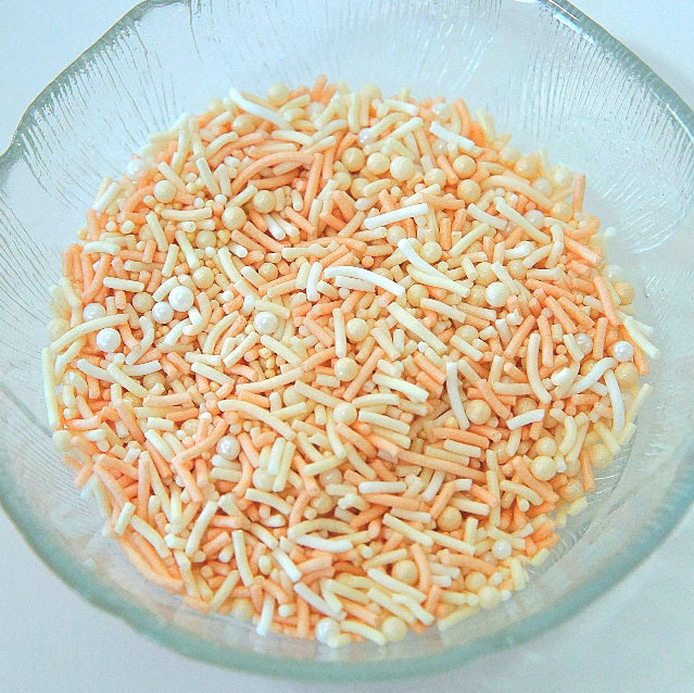 Clear glass bowl filled with colorful sprinkles on a white background