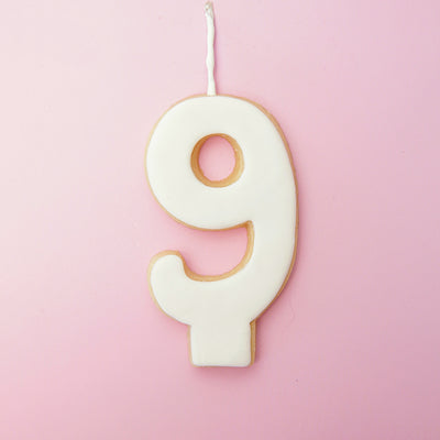 White Number 9 cookie decoration on a pink background