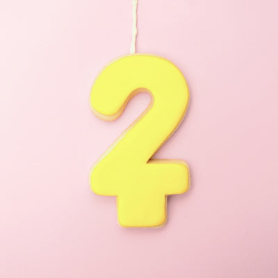 Yellow number '2' cookie on a pink background