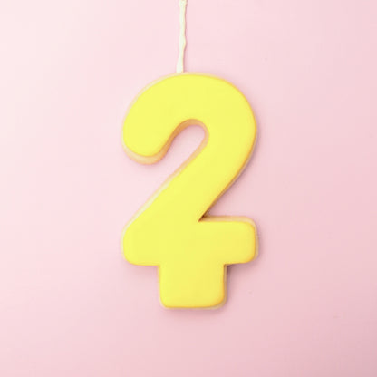 Yellow number '2' cookie on a pink background